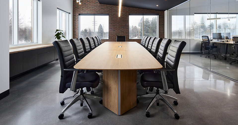 Grande table de conférence ovale en bois avec chaises noires, salle de réunion Laval